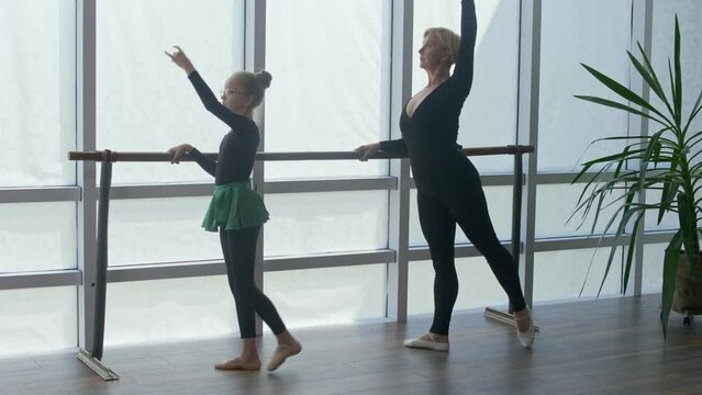 A Professional Female Trainer, Choreographer Teaches Her Pretty Student To Perform Ballet Poses During Classes in a Dance Studio. Sports, Childhood Dream. School of Classical Ballet Dance.