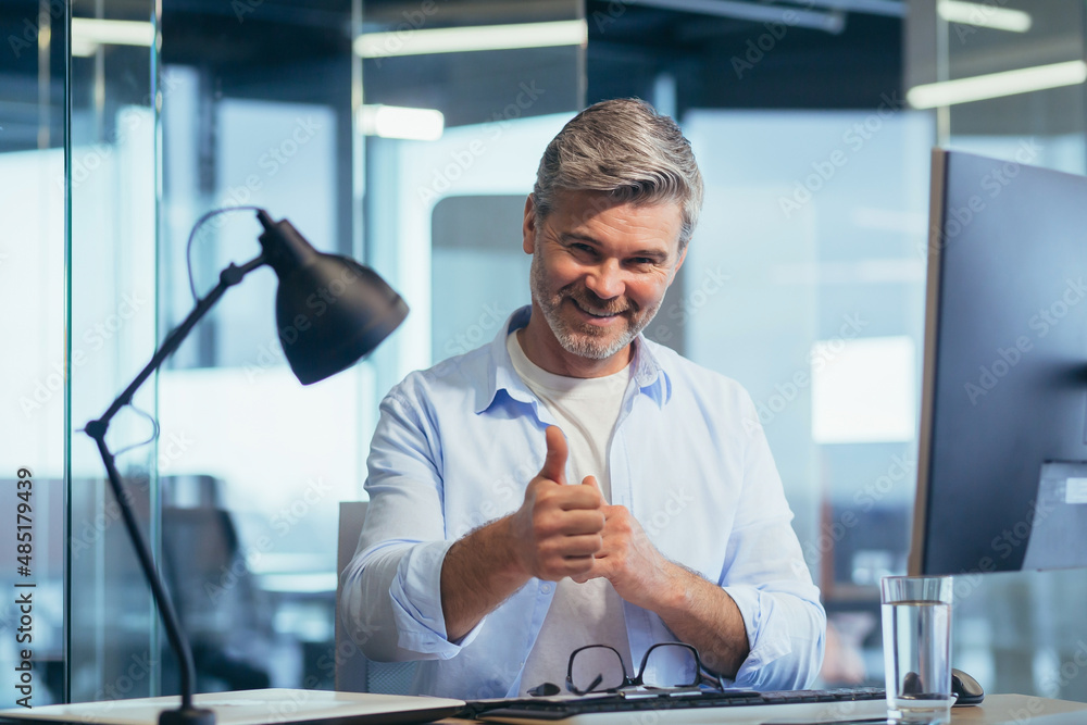 Wall mural portrait of a successful gray-haired businessman, a man looks at the camera and smiles, greets, nurt