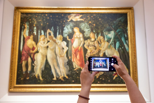 Turist taking picture of Botticelli - Spring. Caucasian woman hands with mobile