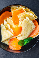 sweet thin pancake persimmon fruit crepe Shrovetide holiday Maslenitsa dessert breakfast pancakes food snack on the table copy space food background 