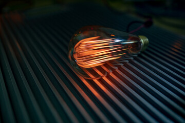 An incandescent lamp illuminates a dark room with orange light