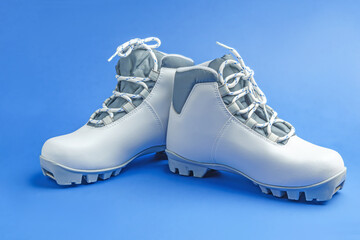 White ski boots on a blue background with a nose mount