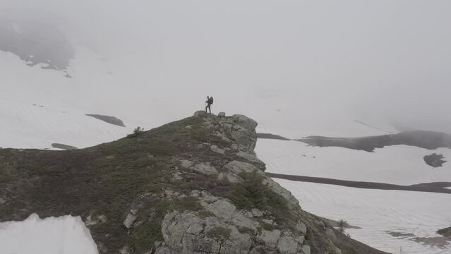 Challenging trekking of solitary hiker in cold and hostile mountain weather