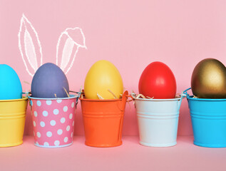 Easter eggs with bunny Rabbit ears in colored buckets, selective focus image, Card Happy Easter	