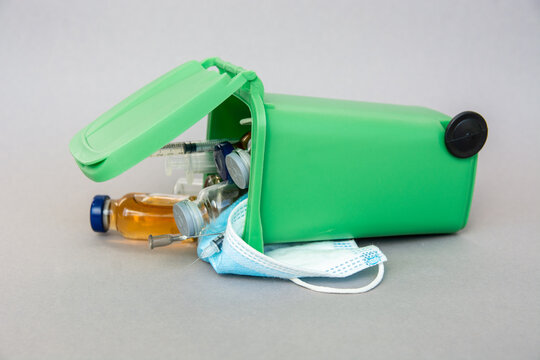 trash container with medical waste, end of the pandemic. syringe, ampoule, vaccine, face mask - medical pandemic items