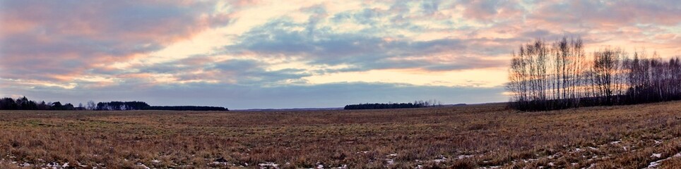 Panorama.Sunset over fields and meadows in winter.