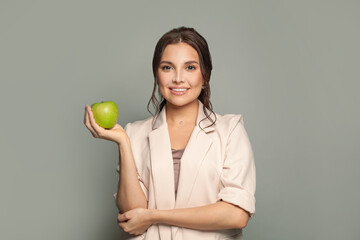 Beautiful woman with healthy teeth holding green apple