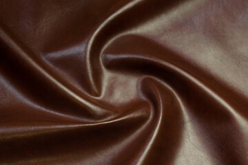 brown artificial leather with waves and folds on PVC base