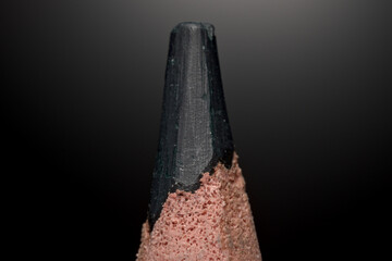 A sharpened crayon close-up macro with visible details on a black background.