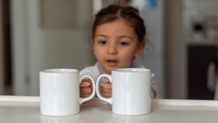 two mugs mockup. two white mugs in the hands of the beautiful little kid. image that can increase...