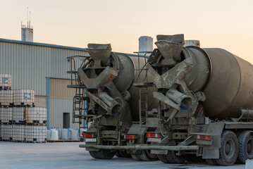 Two concrete mixer trucks seen from behind.
