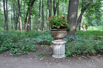 Stone vase with flowers in a summer park.