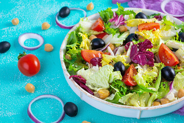 Vegetarian salad with chickpeas, tomatoes, olives and lettuce. Diet salad food