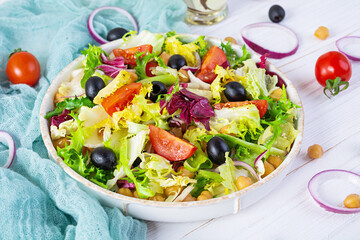 Vegetarian salad with chickpeas, tomatoes, olives and lettuce. Diet salad food