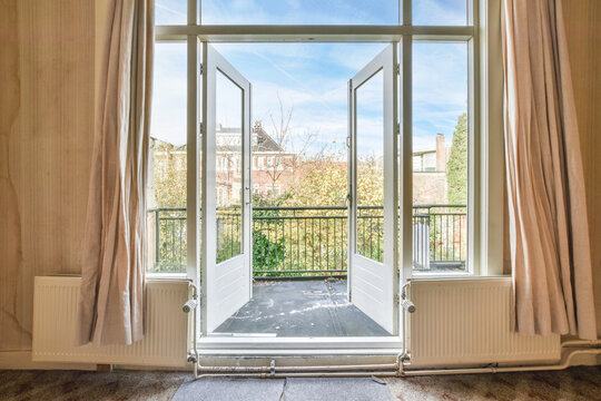 opened doors of the balcony of a classic house