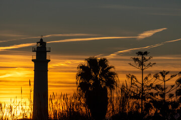 atardecer en la playa con faro