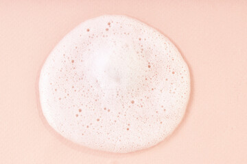 Cleansing foam with bubbles on beige background. Hygiene healthcare background. Shampoo  texture