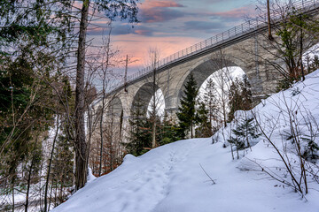Wiadukt kolejowy w górach zimą nad rzeką i drogą. Wisła, Beskid Śląski w Polsce - obrazy, fototapety, plakaty