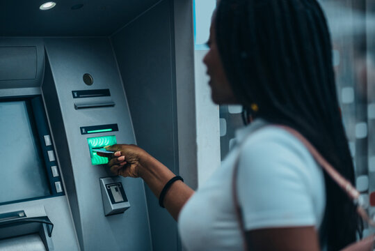 Beautiful african american woman using atm machine and a credit card