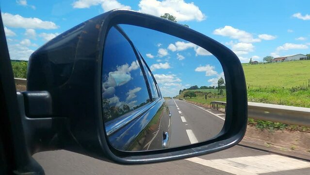 Image of a car rear view of a summer day in the state of Paraná in Brazil. A highway with soy plantations.