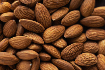 Close up almonds on dark wooden table. Organic health protein vegetarian food concept. Background