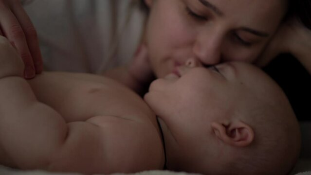 Newborn Baby With Young Mom look Into Each Other Eye. Cute Smiling Teethless Kid Face Portrait. Woman Kissing With Child Look At Camera. Infant, Mother Day, Childbirth, Beginning, Relationship Concept