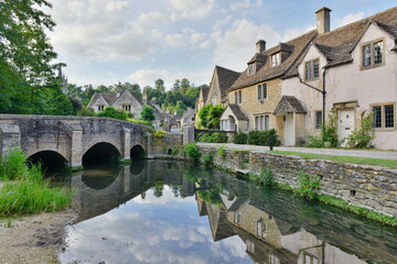 Fototapeta na wymiar Scenic view of traditional old cottage houses by a river in a beautiful English village - namely the landmark village of Castle Combe in Wiltshire England
