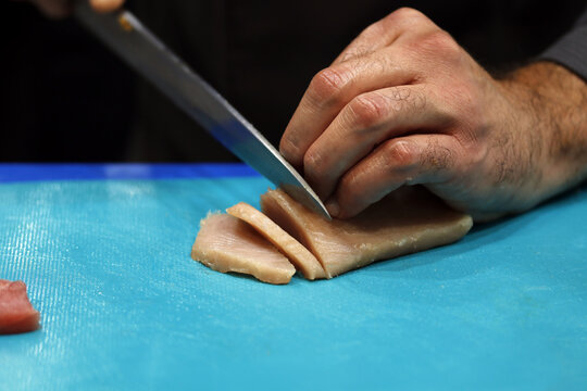 Chef elaborando sushi cortando pez mantequilla