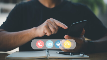 Contact us or the connected customer support hotline. Businessman using laptop and tapping contact icon on virtual screen, phone, email, address, live chat, internet, available 24 hours a day.