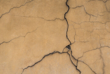 Cracked cement wall facade. Concrete wall cracks. Patterned background