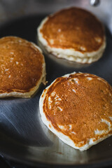 Golden Pancakes Flipped in Hot Pan. Homemade Pancakes Cooking in a Stainless Steel Pan. Cooking Breakfast Lifestyle.