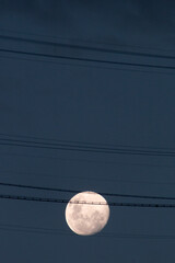 Full moon with communication wires silhouette in Rio de Janeiro, Brazil.