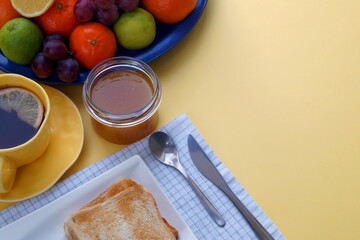 yellow sunny background improves appetite. A breakfast of toast with jam or honey along with tea...