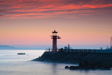 Fototapeta na wymiar Sunrise on the beach with a view of the lighthouse 