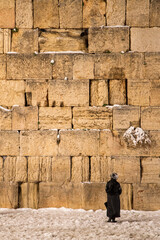 Naklejka premium orthodox jew at the western wall with snow in jerusalem