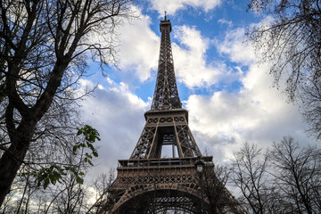 Fototapeta na wymiar eiffel tower in paris through trees of champ du mars and close up