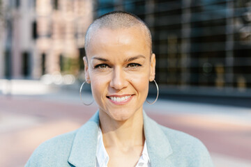 Confident mid adult businesswoman with short hair looking at camera - Female successful manager standing in financial district