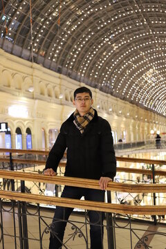 Happy man in the mall standing on the bridge and smiling