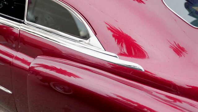 This video shows a rear view of a kustom chopped 1950 - 1951 Cadillac with a beautiful red paint job.