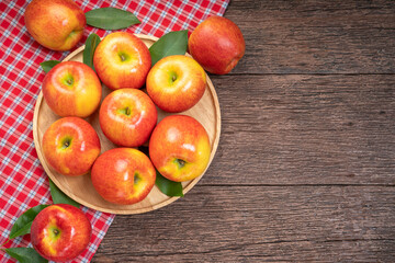 Red apple in wooden plate on wooden background, US. Red Envy apple on wooden table.