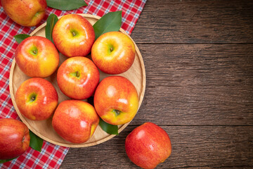 Red apple in wooden plate on wooden background, US. Red Envy apple on wooden table.