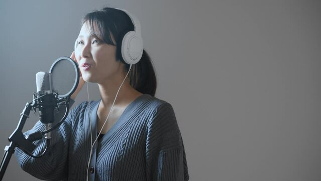 歌の収録をする若い女性