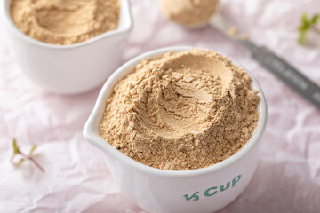 Maca powder in measuring cups and a spoon
