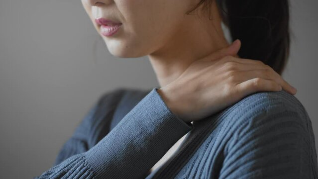 肩コリをほぐす若い女性