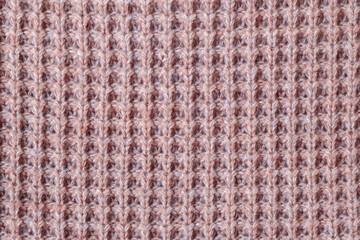 Fototapeta premium Texture of knitted woolen fabric of light red color.