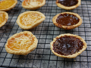 Pineapple, cheese and chocolate flavored pies on a cooling rack. bakery food concept