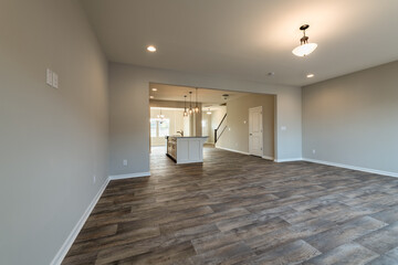 Empty modern townhouse floor showcasing a kitchen with living and dinning room ready to be moved in. Investment, renting, or house ownership concept.