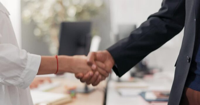 Close-up of women and men hands in the middle of a corporate office in the background, friendly shaking hands, greeting, saying goodbye, getting acquainted, congratulating, pride, joy