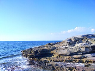 晴れた夏の日の和歌山県白浜町の観光スポット千畳敷に打ち寄せる波と海と青空の自然風景【コピースペースあり】