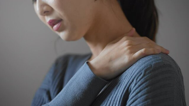 肩コリをほぐす若い女性